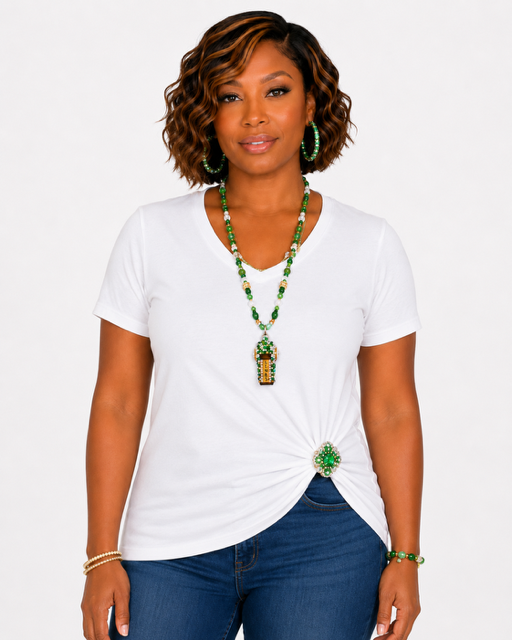 Woman wearing a white t-shirt with a green beaded necklace against a plain background