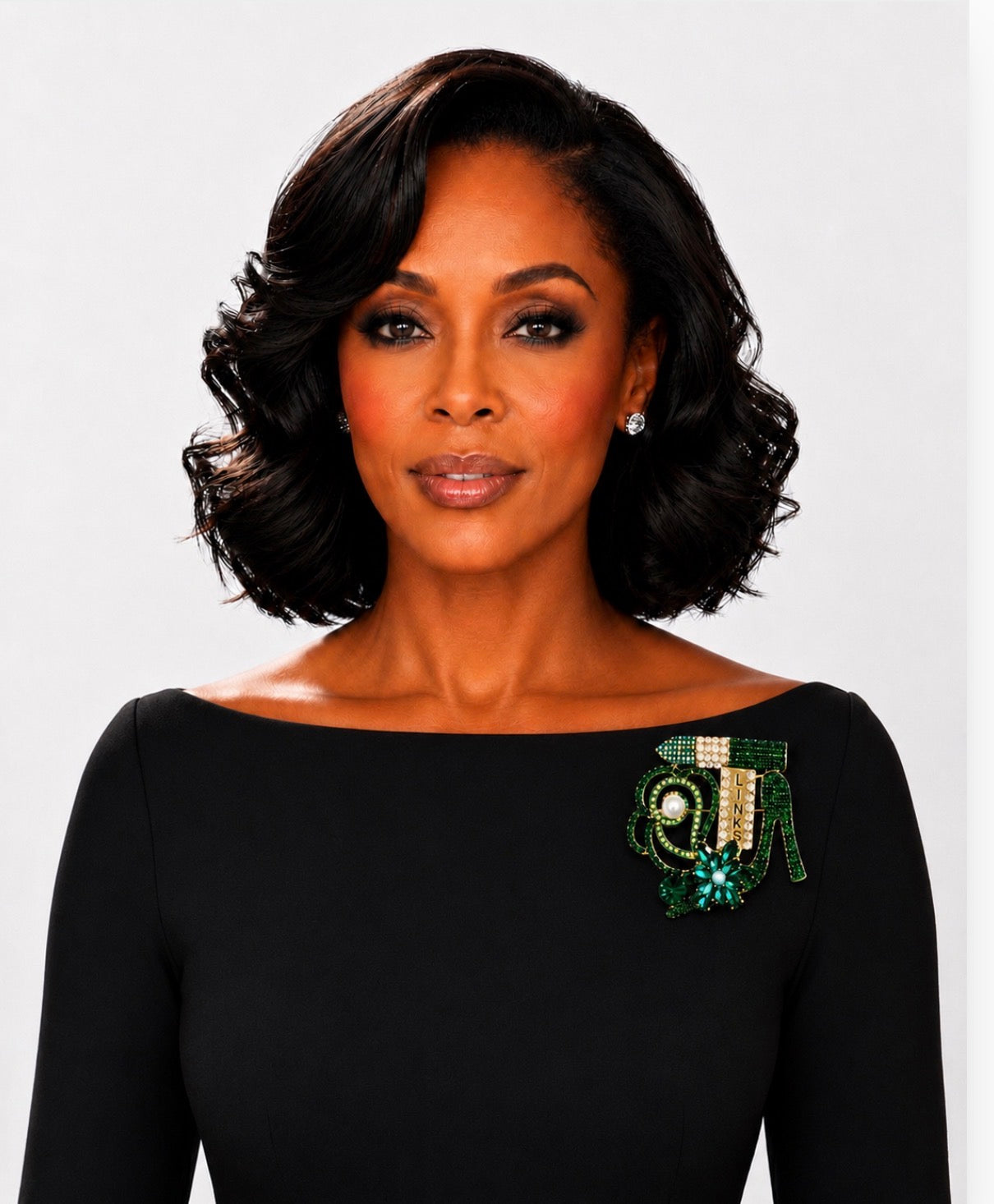 Woman wearing a black dress with a decorative brooch on a white background